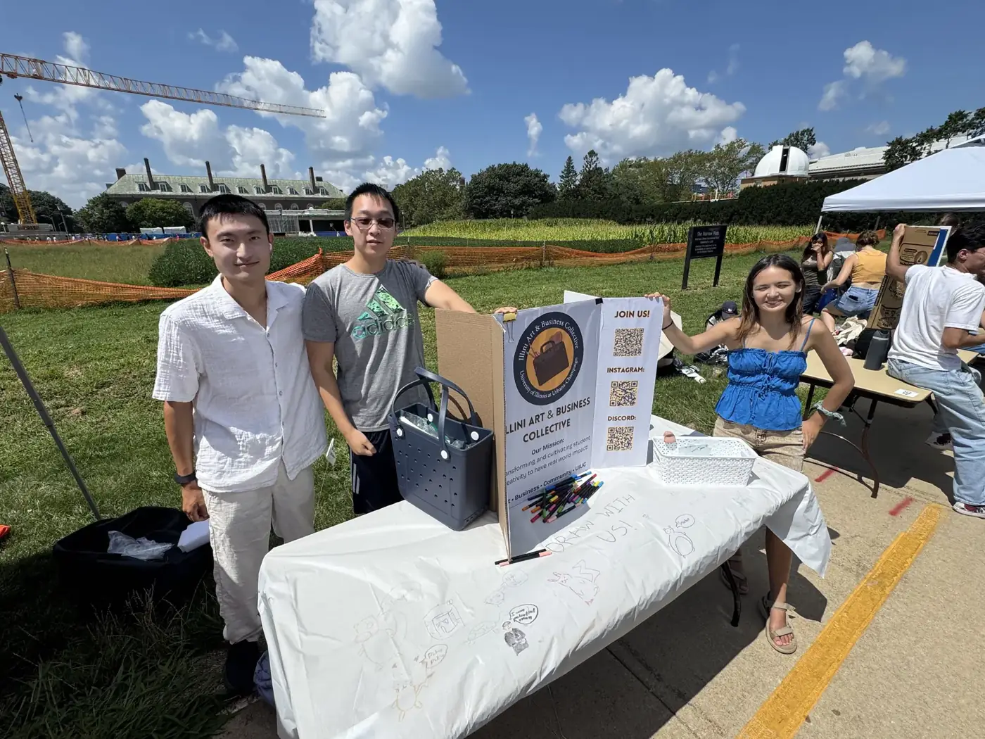 Three members at the club table on the Main Quad during Quad Day